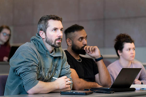 Photo of a group of Chatham students in a lecture hall, listening to class.