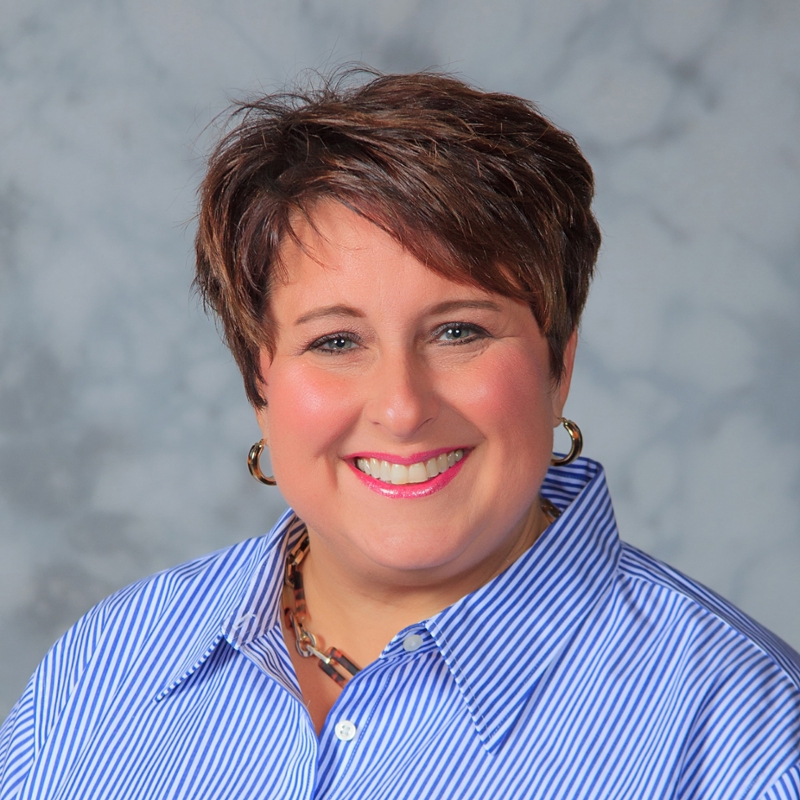 Headshot of Chatham University alumna in a striped blue shirt.