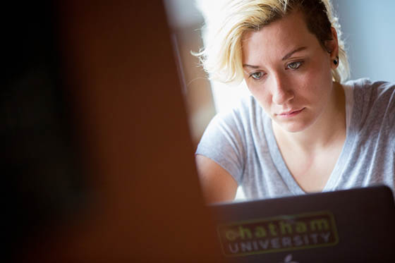 Photo of a Chatham University student working at her laptop in Cafe Rachel