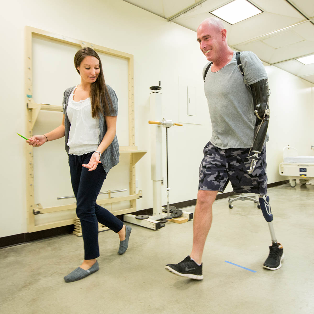 Physical Therapy student walking with an amputee in hospital