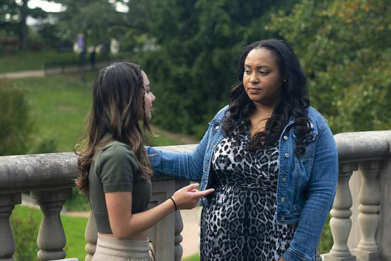 Photo of a student success coach speaking to a student outside on Shadyside Campus
