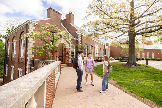 Three students stand together and chat on Shadyside Campus