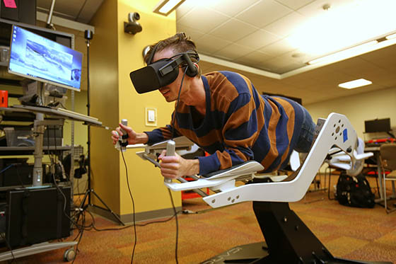 Photo of a student in a virtual reality machine in the immersive media lab