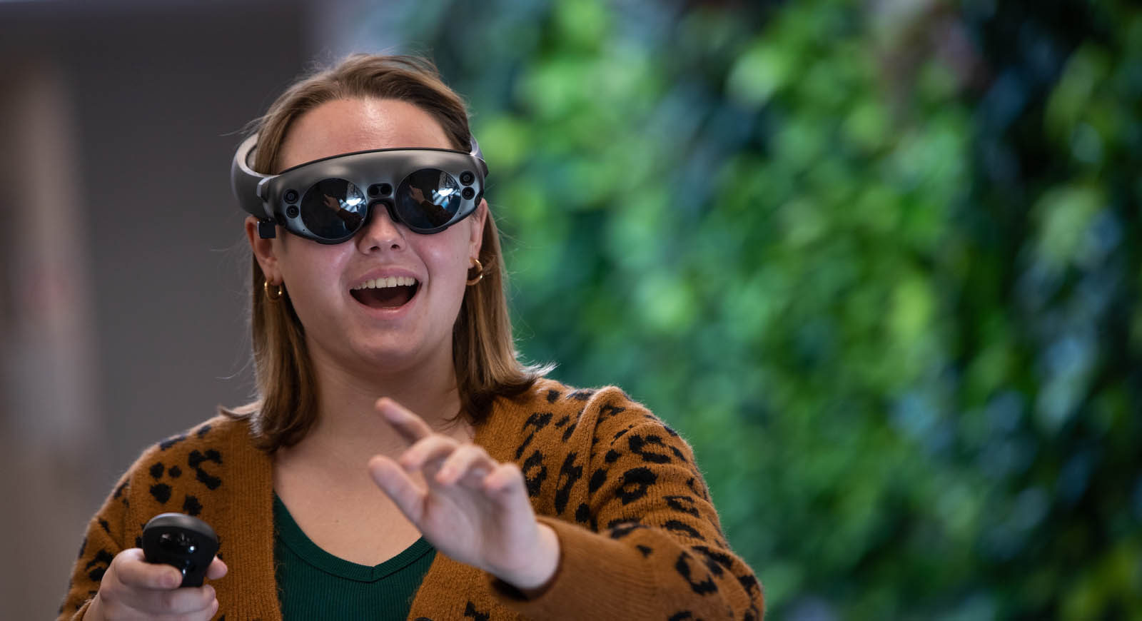 Photo of a Chatham University student in virtual reality goggles smiling