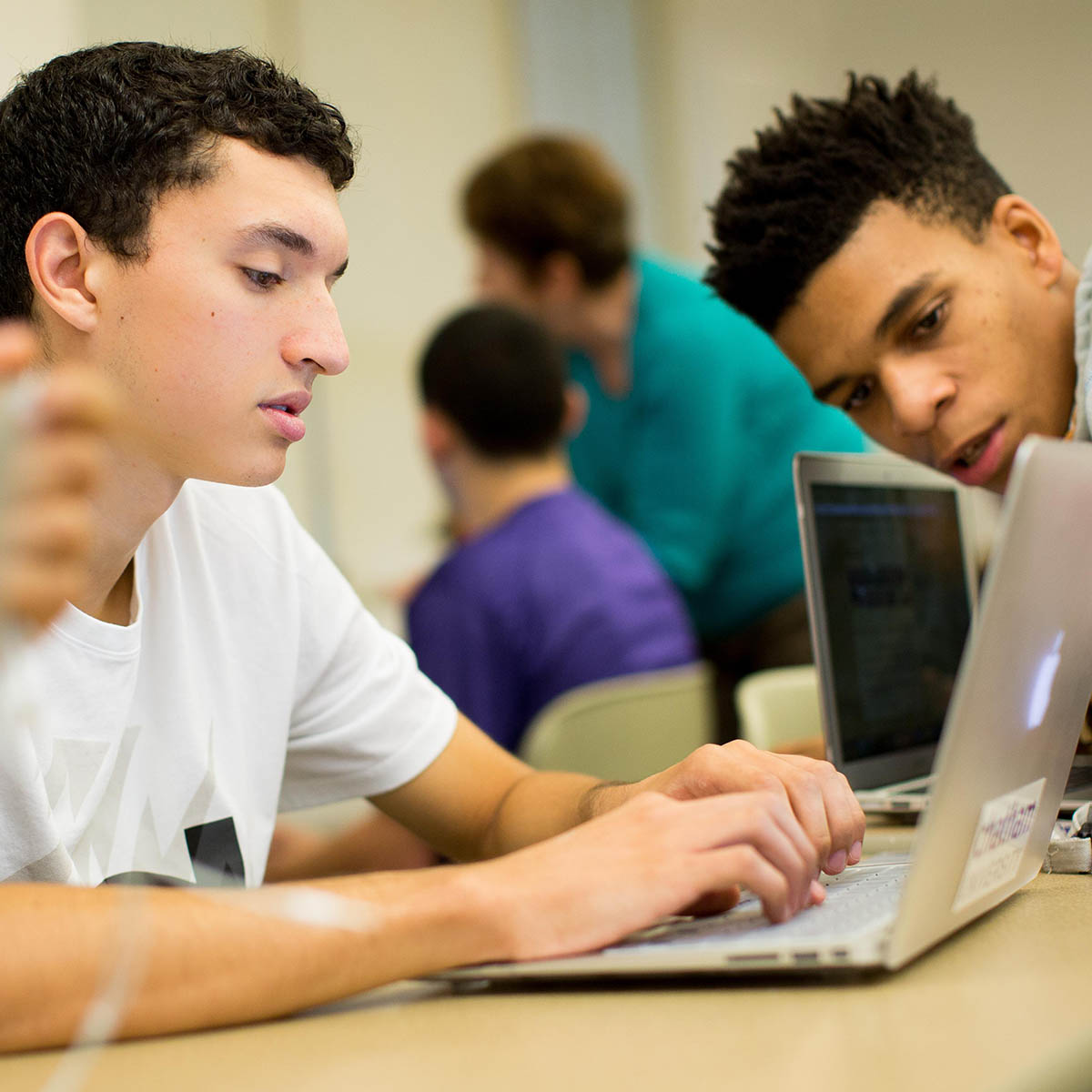Photo of students working on a laptop together in the classroom