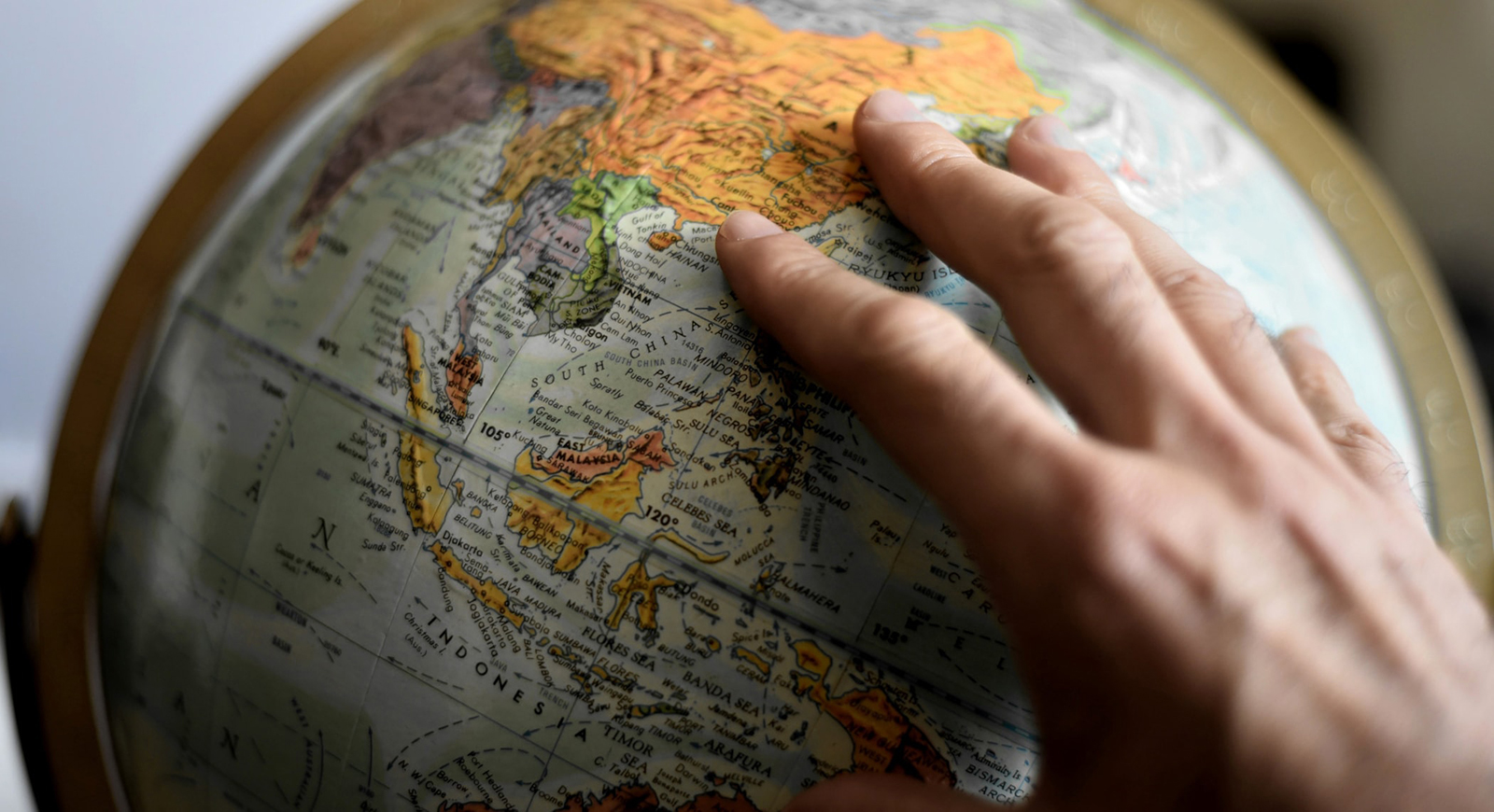 Photo of a hand resting on a globe