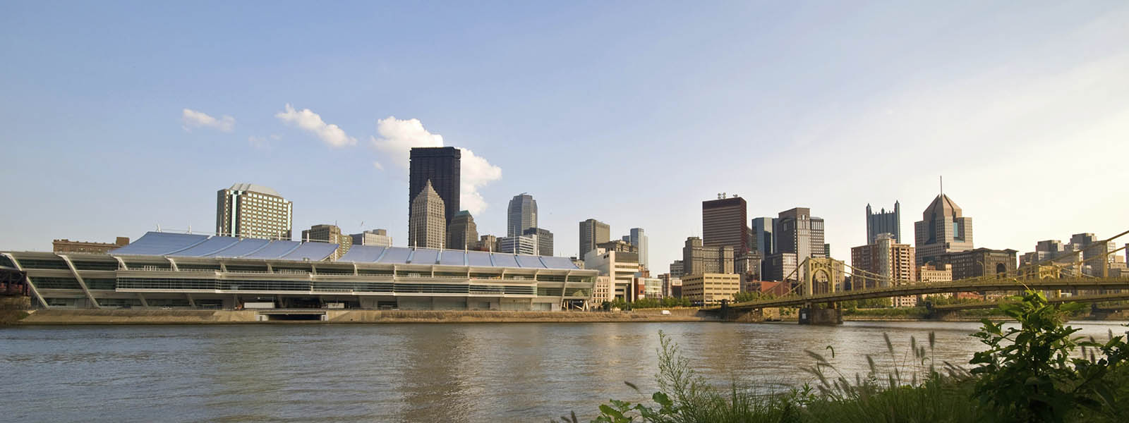 Photo of the Pittsburgh skyline and river with yellow bridges