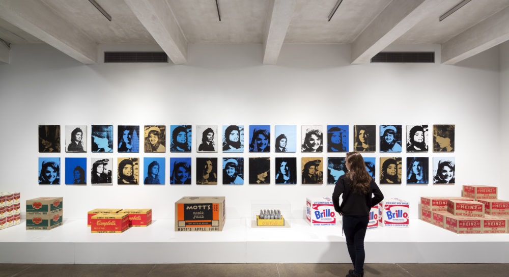 Photo of a person examining artwork at the Andy Warhol Museum