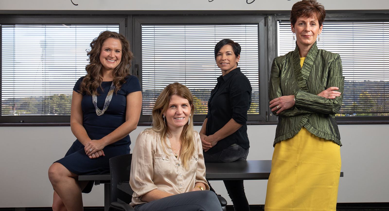 Photo of four women posing together in an office at Center for Women's Entrepreneurship at Chatham.