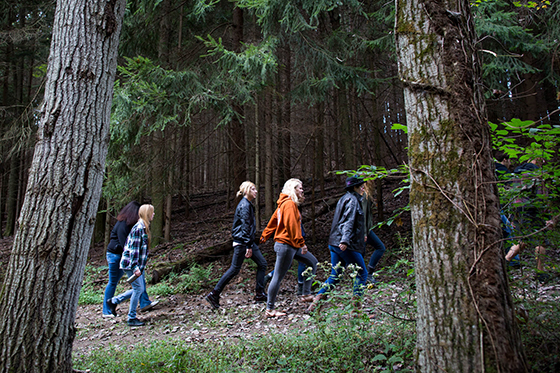 Photo of students walking through a forest on Eden Hall Campus