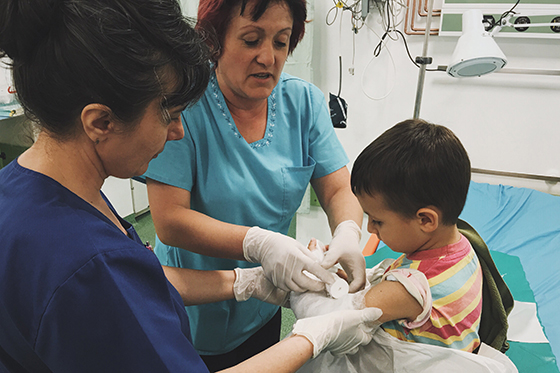 Photo of two nurses helping a child