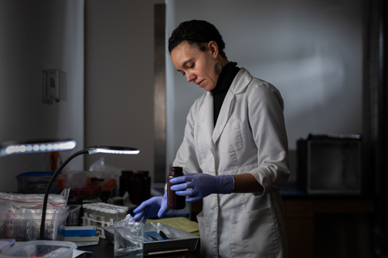 Photo of a woman in a white lab coat, working in a laboratory