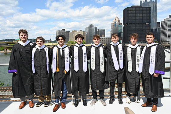 Three Chatham University graduates in gowns and caps pose for a photo