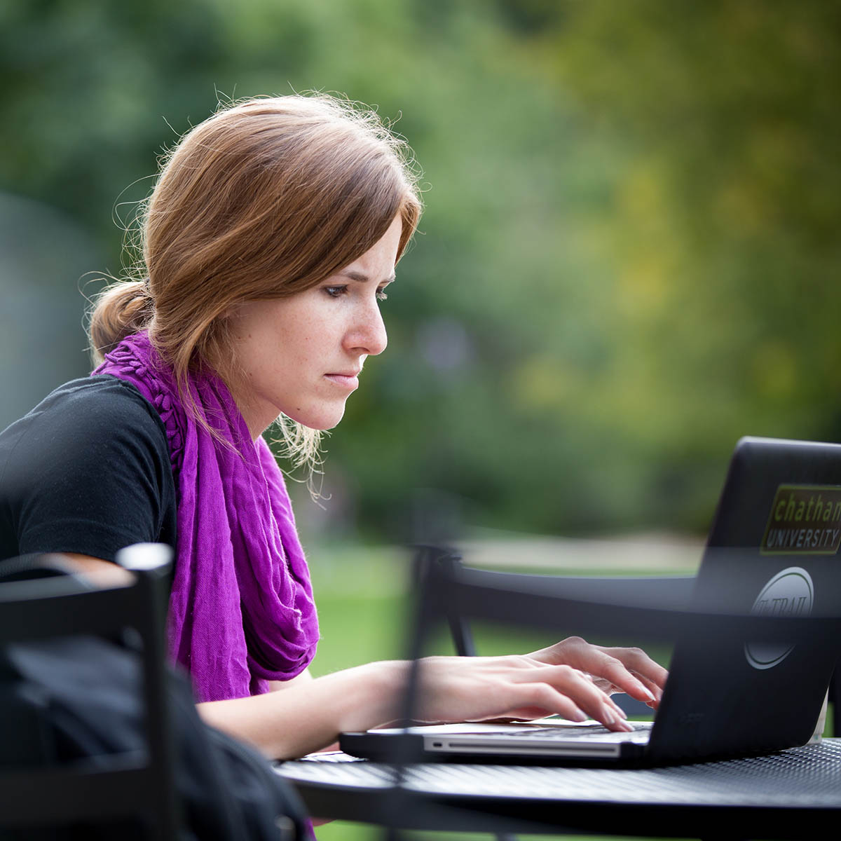Chatham online student works on her laptop outside