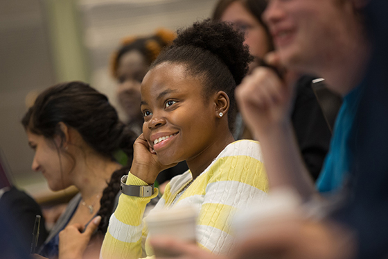 Photo of a female Chatham University student smiling while paying attention during a lecture