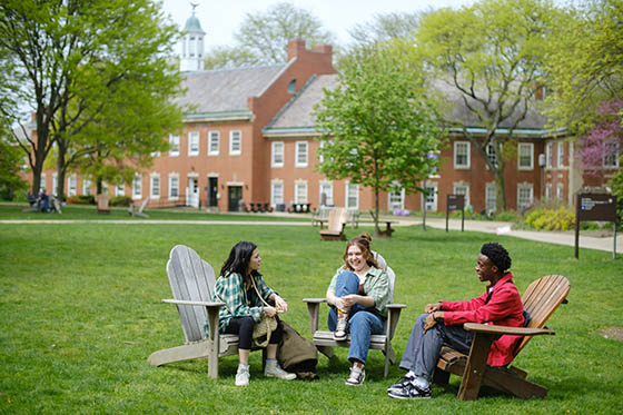 Students sit outside on chairs, in Shadyside Campus's quad