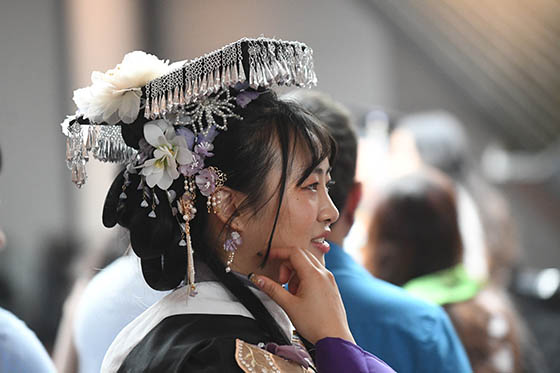 Profile of a student wearing decorated graduation cap and robe