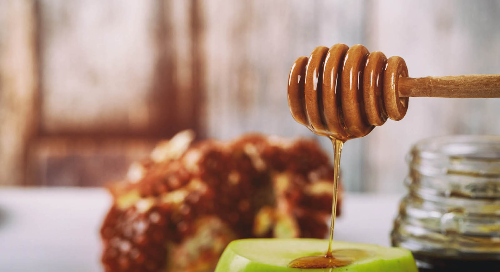 Photo of honey dripping from a wooden honey dipper