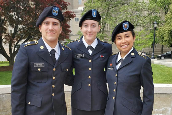 Photo of three people in military uniforms posing for a photo