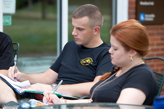 Photo of a military student working at a table outside at Cafe Rachel