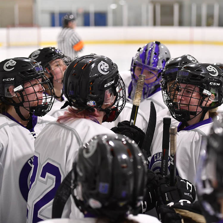 Photo of the Chatham University's women's ice hockey team in a huddle on the ice