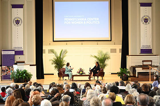 A PCWP event with audience in the foreground and two women on stage