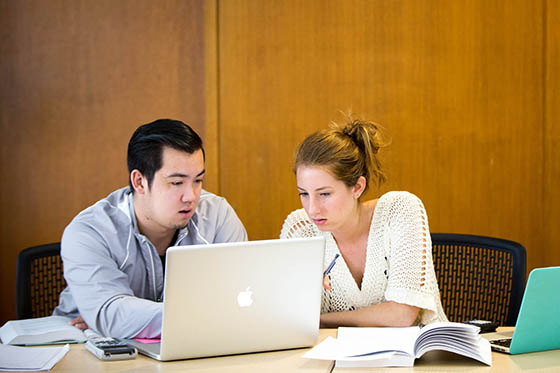 Photo of two Chatham University students looking at a laptop together.