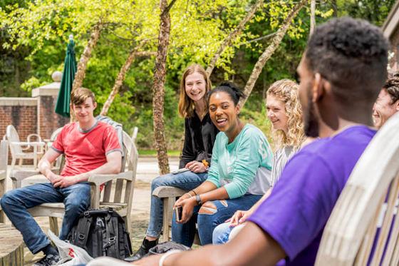 Photo of Chatham University students outside, laughing and talking, on Shadyside Campus
