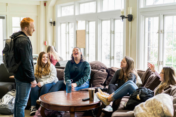 Photo of a group of Chatham University students laughing together in a lounge