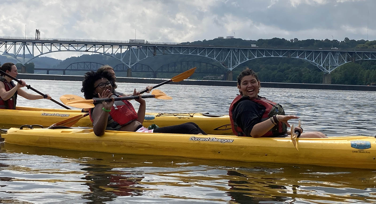 Photo of two SLA attendees in kayaks on a Pittsburgh river, smiling for a photo