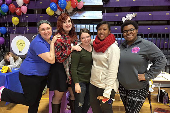 Photo of a group of Chatham students posing at an event, with balloons in the background