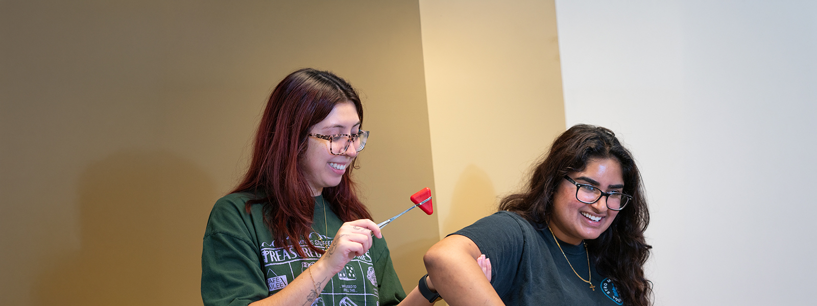 Two physician assistant graduate students testing reflexes together