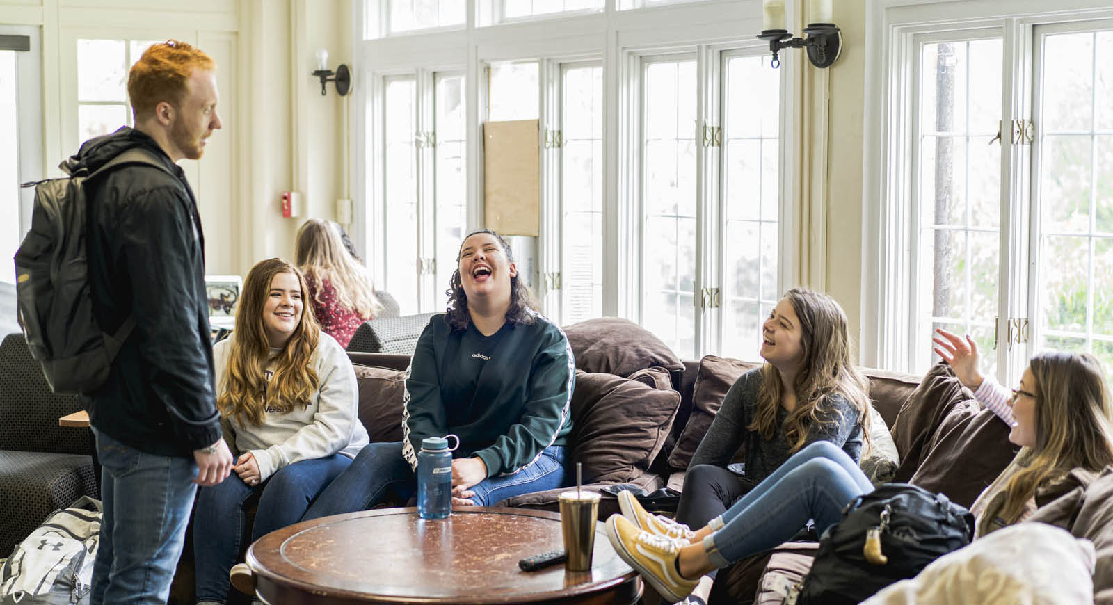 Photo of a group of Chatham University students laughing together in a lounge