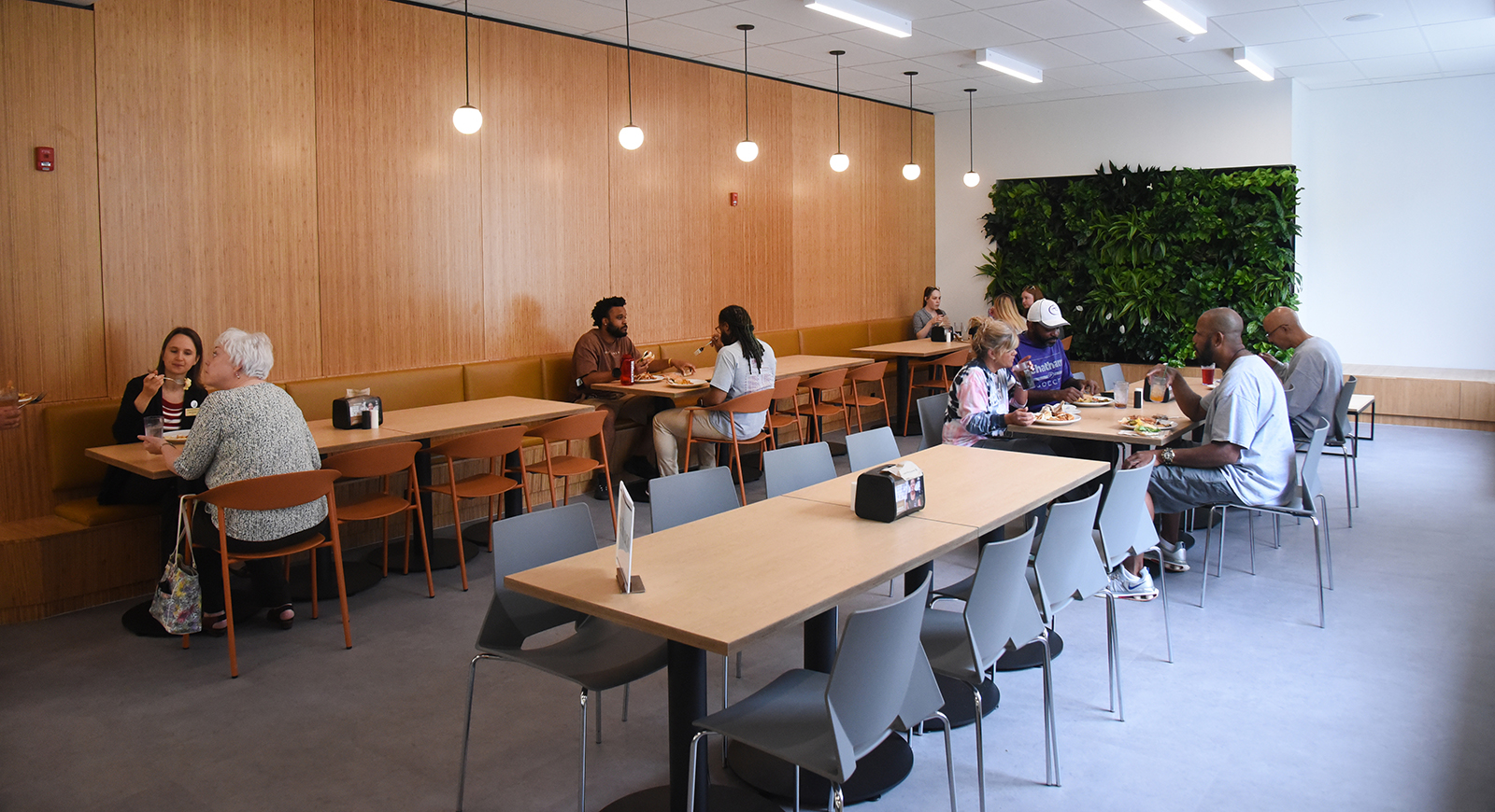Photo of people eating in Anderson Dining Hall, near a plant wall