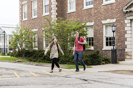 Photo of two Chatham University students crossing a street on Shadyside Campus