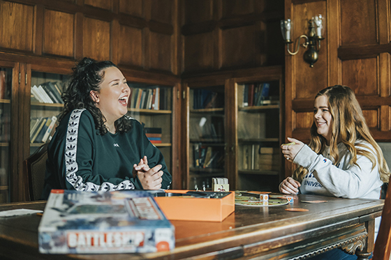 Photo of two Chatham University students hanging out in a historic mansion that's been converted to University housing